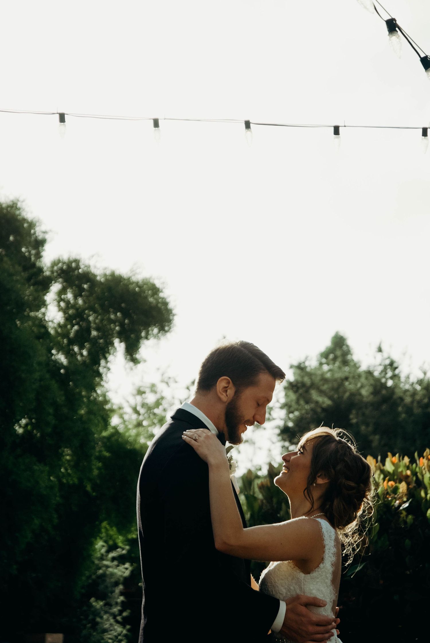Bride and groom looking at each other lovingly while sharing their first dance as a married couple.