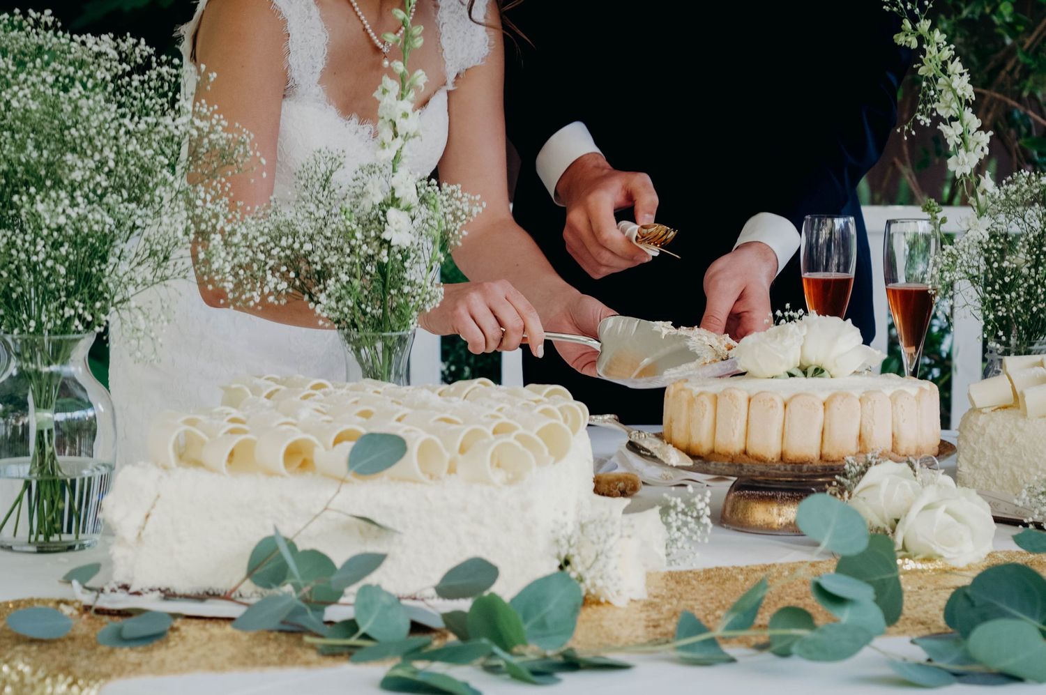 Bride and groom cutting cake for their guests at the reception of their wedding.