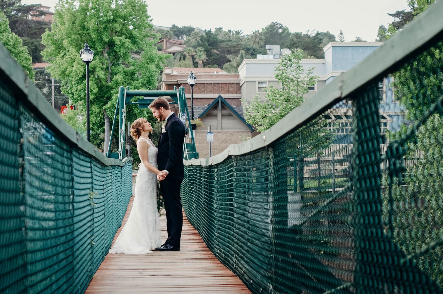 Bride and groom stand on a bridge together after saying 