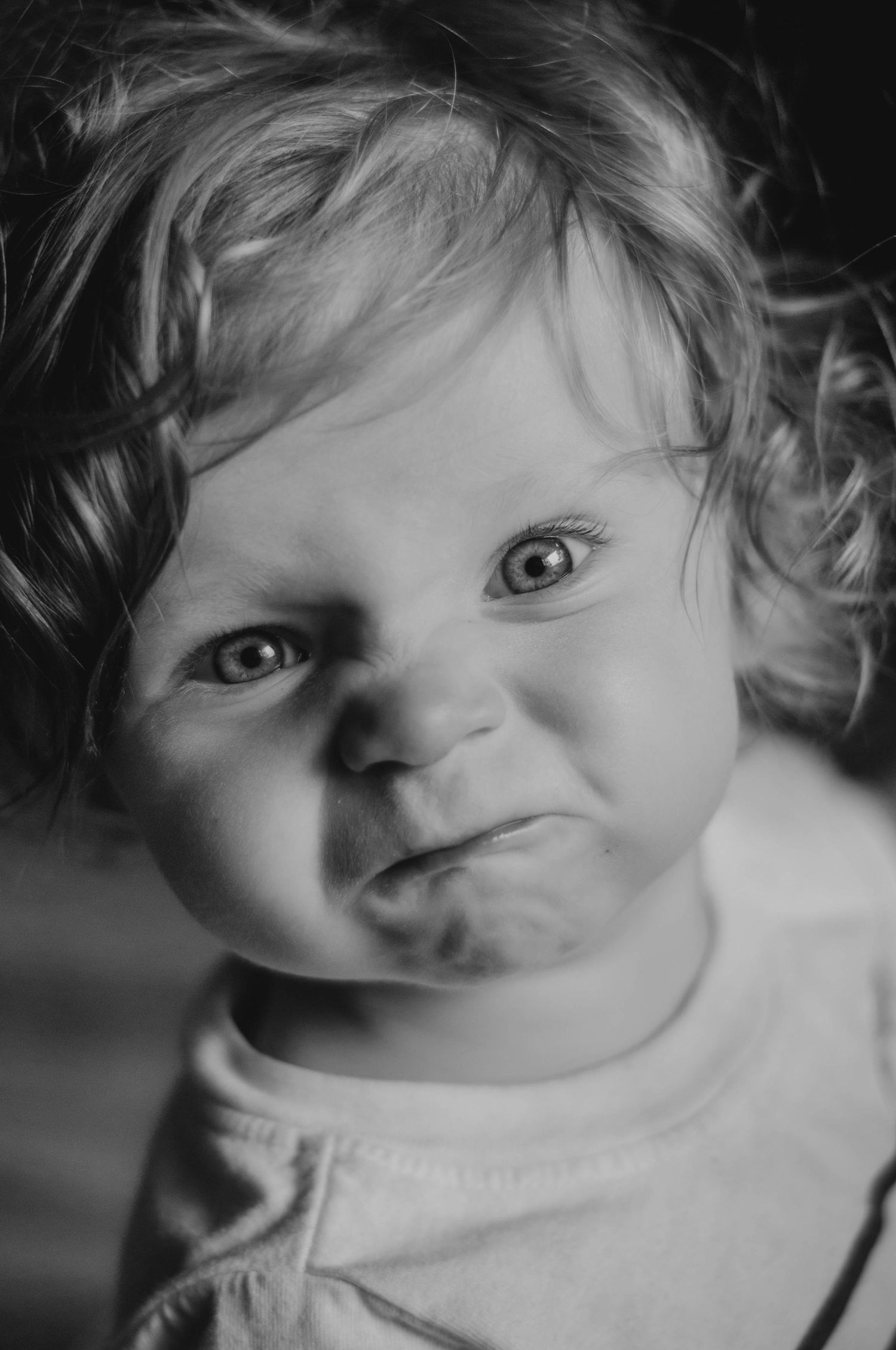 Baby makes adorable scrunchy face at camera.