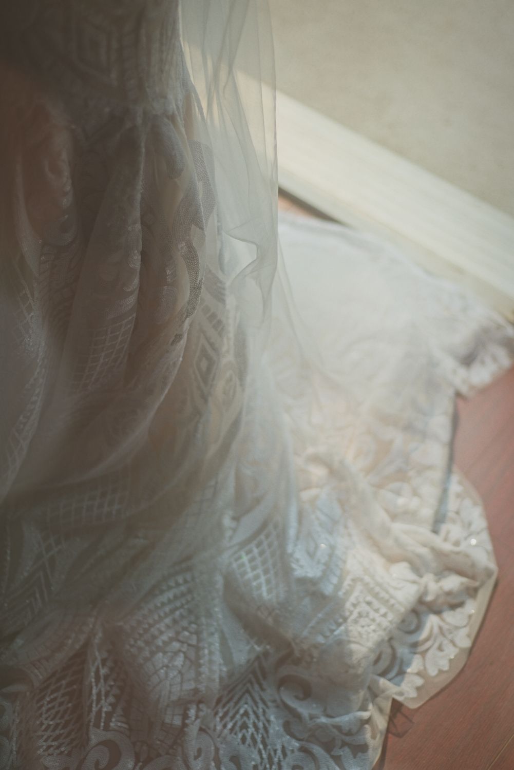 Close up details of the lace on the bride's dress.