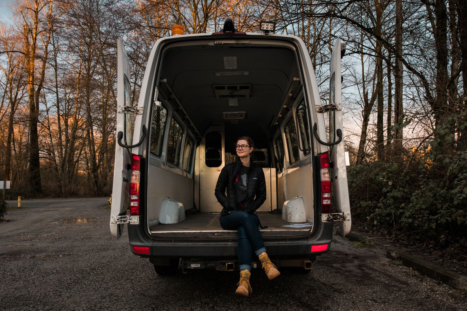 Photographer sitting in newly purchased van to be converted in to a home on wheels.
