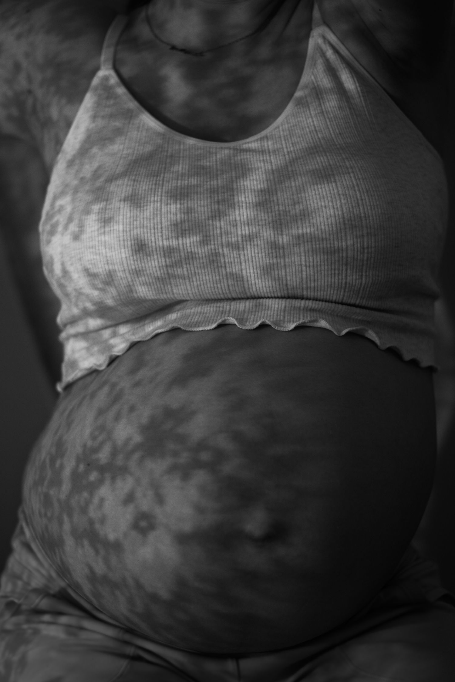 Pregnant belly in the shadow of lace.