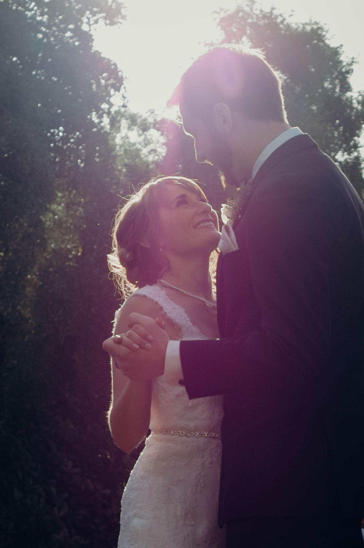 Bride and groom looking at each other lovingly while sharing their first dance as a married couple.