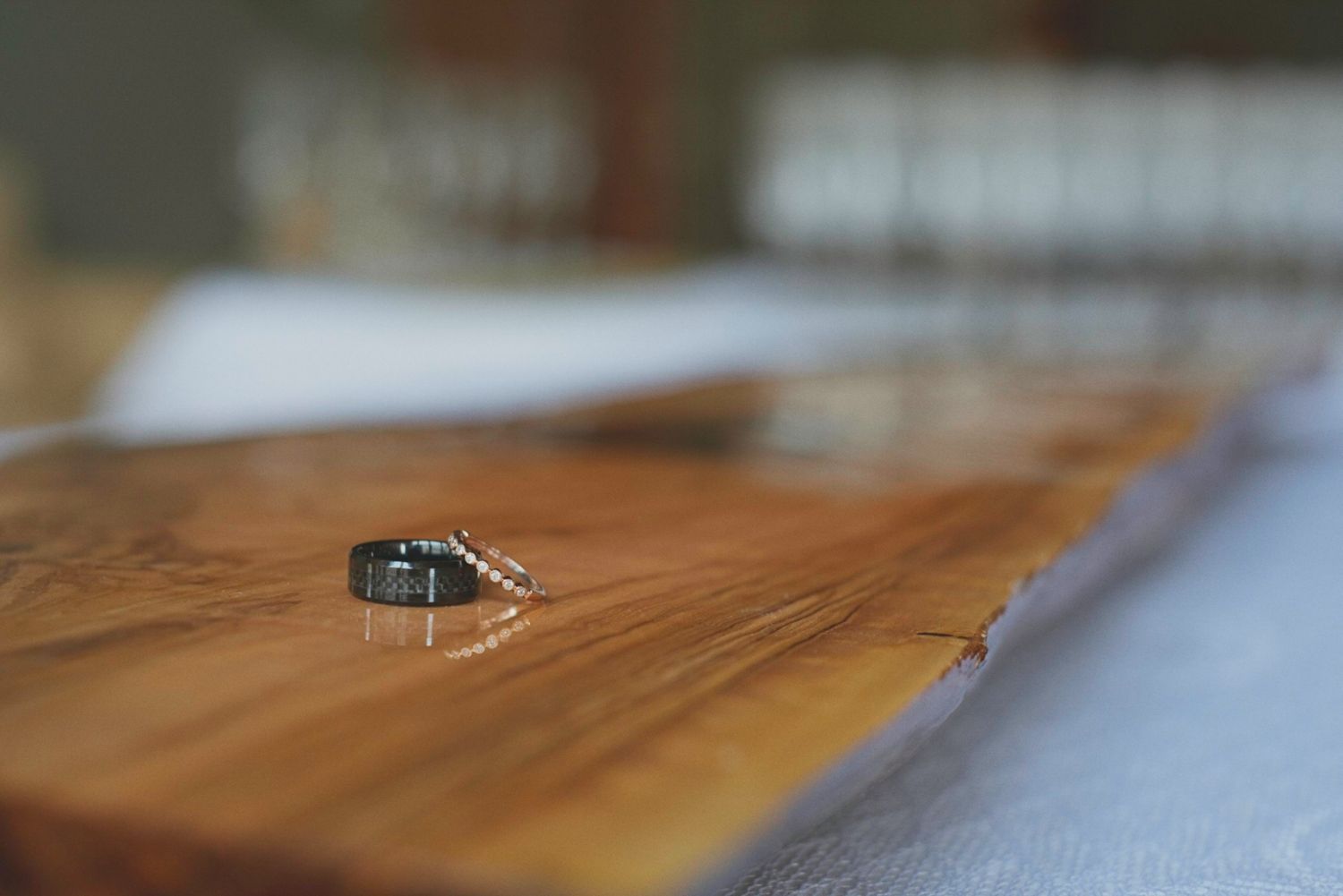 Close up shot of bride and groom's wedding rings on a plank of wood.
