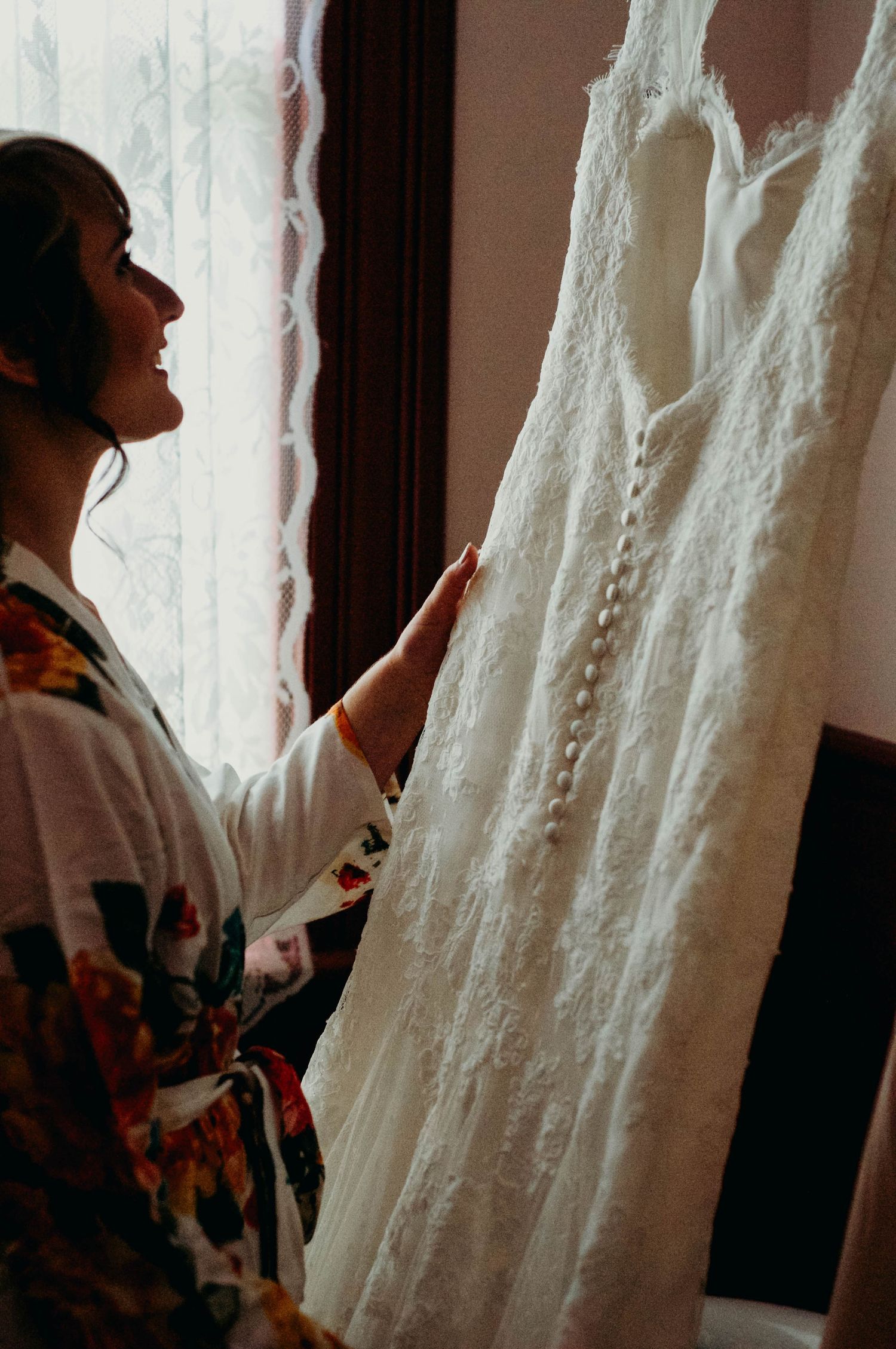 Bride inspecting her bridal gown before putting it on.
