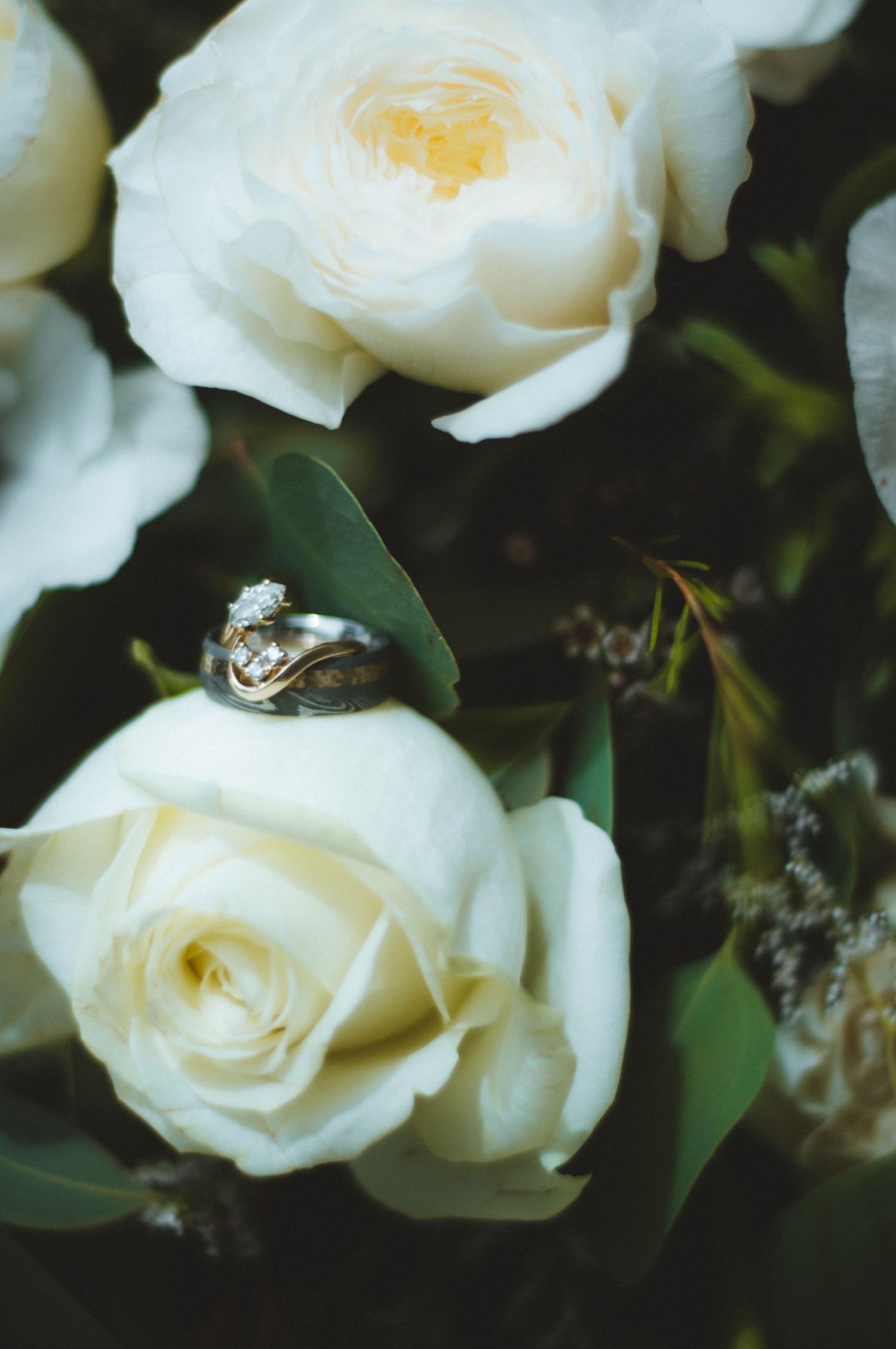 Bride and groom's wedding bands with the bride's flower bouquet.