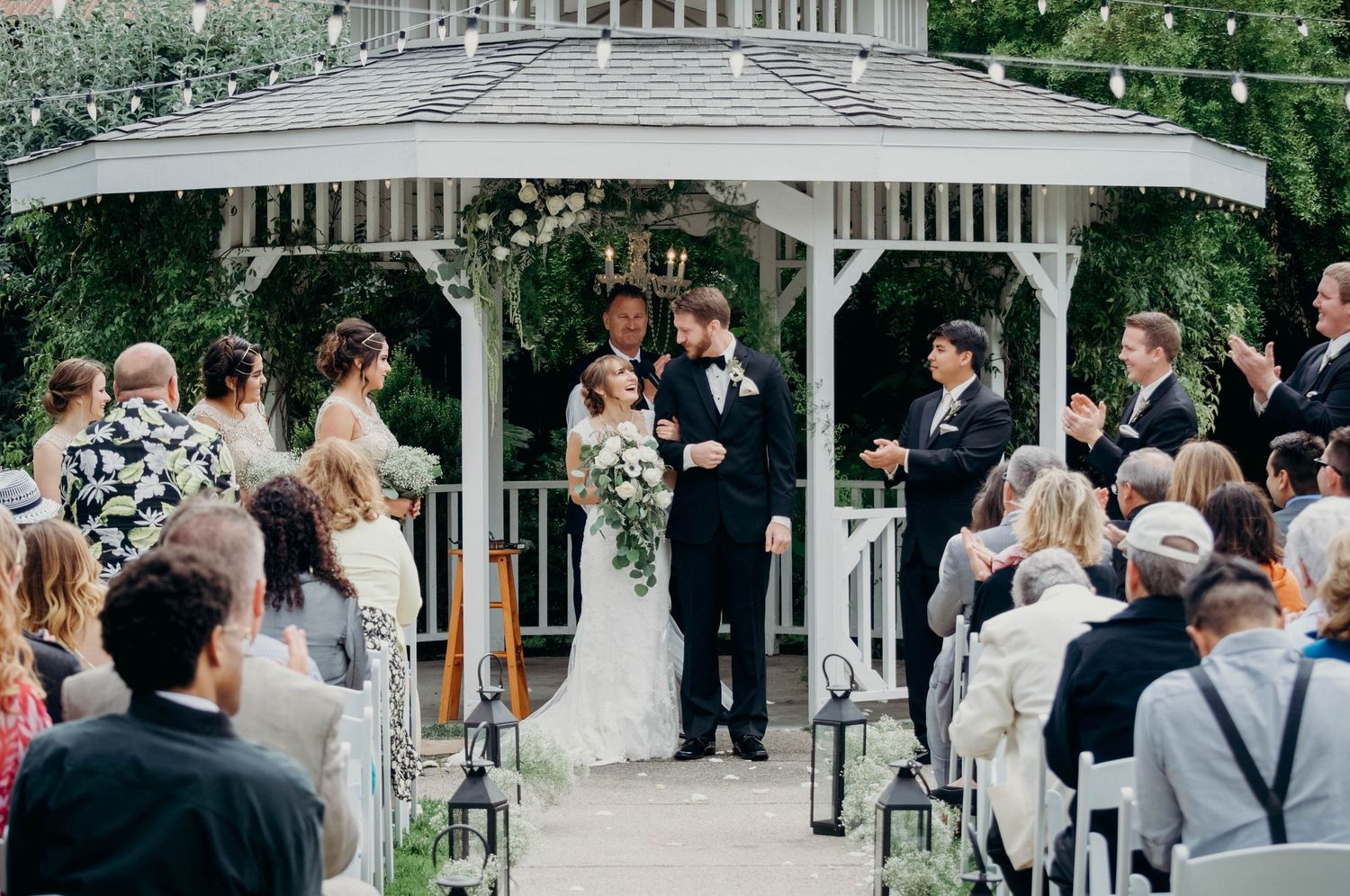Bride and groom laugh at the altar as their guests clap after being pronounced as husband and wife.
