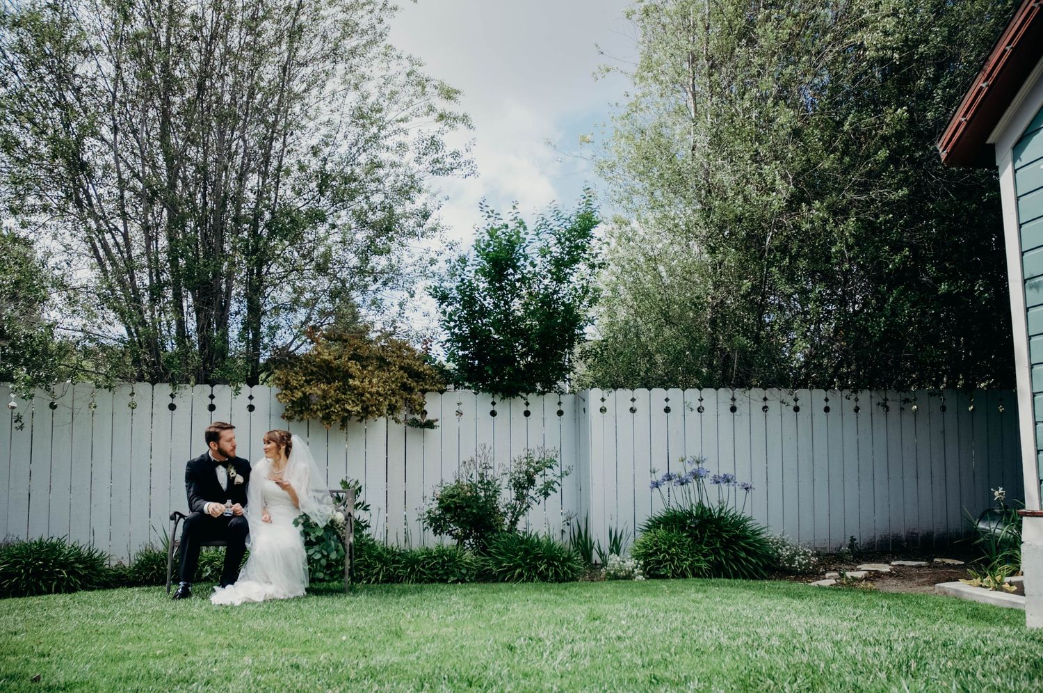 Bride and groom share a quiet moment together on a bench just after being officially wed.