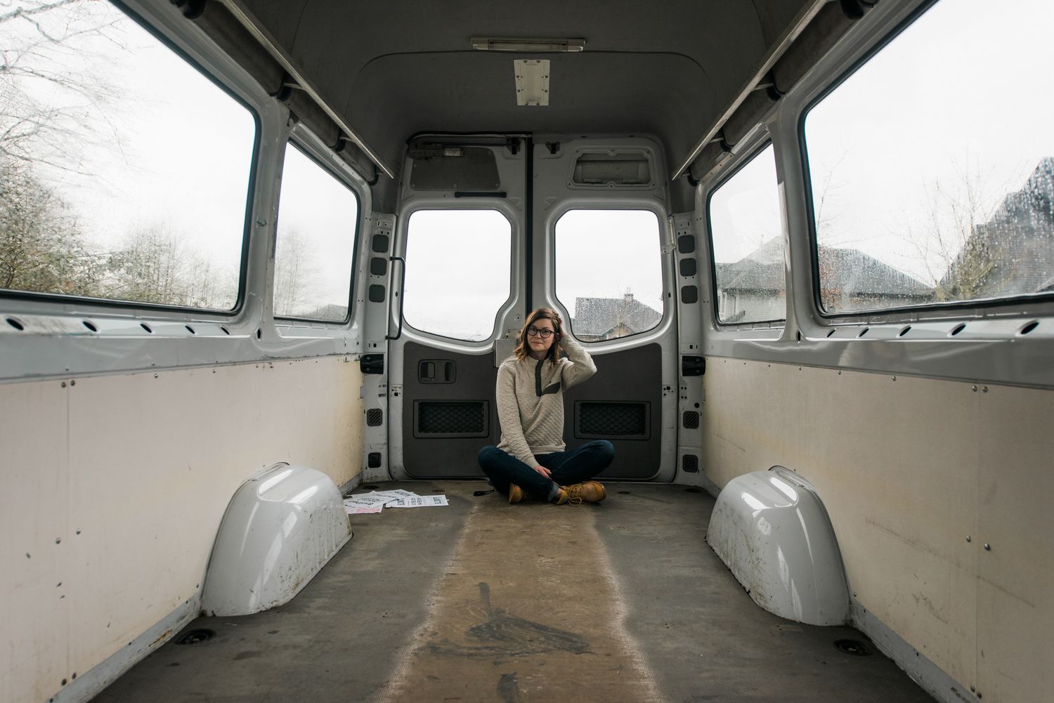 Photographer sitting in newly purchased van to be converted in to a home on wheels.