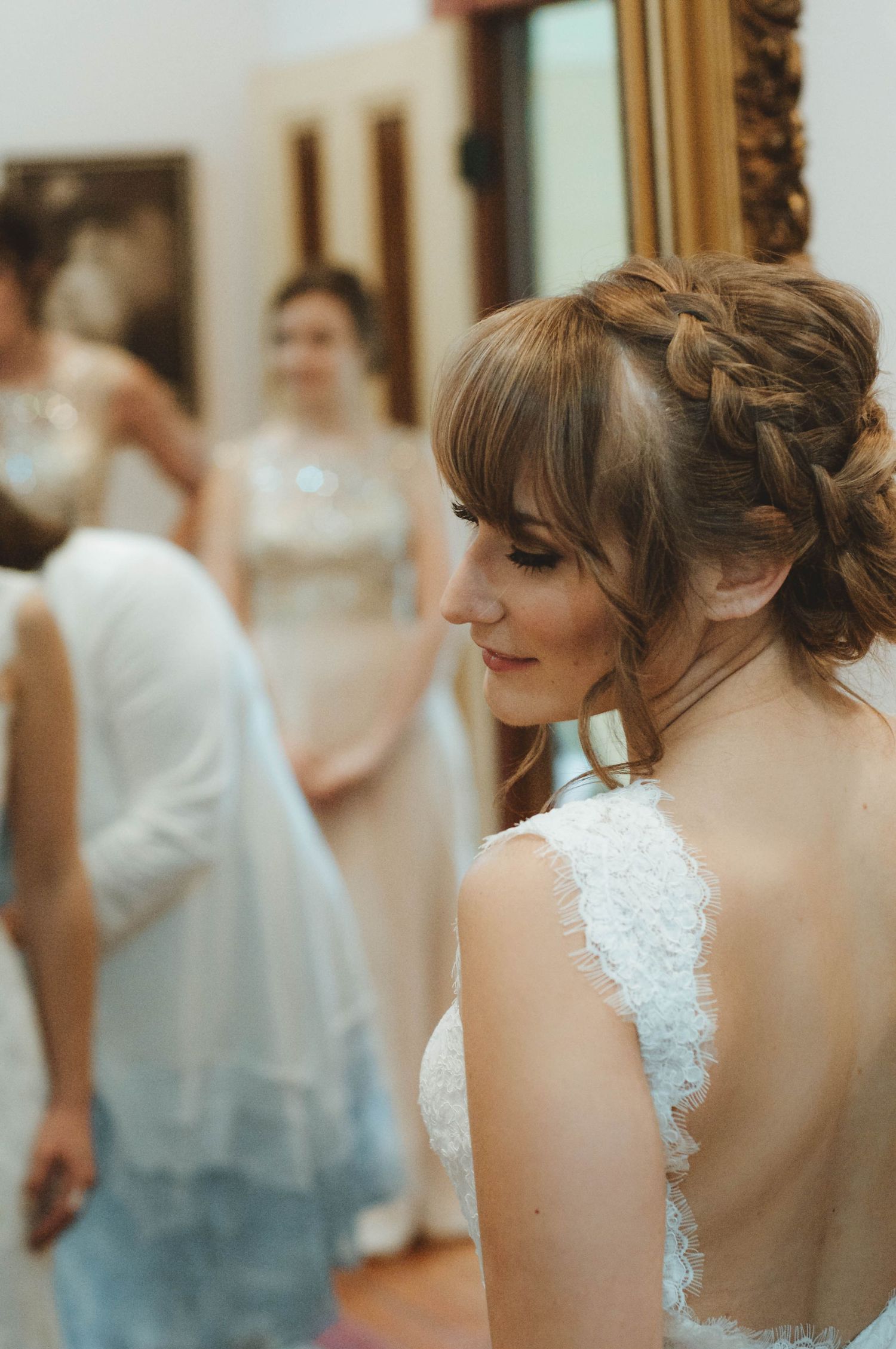 Bride getting ready with her bridesmaids in the background.