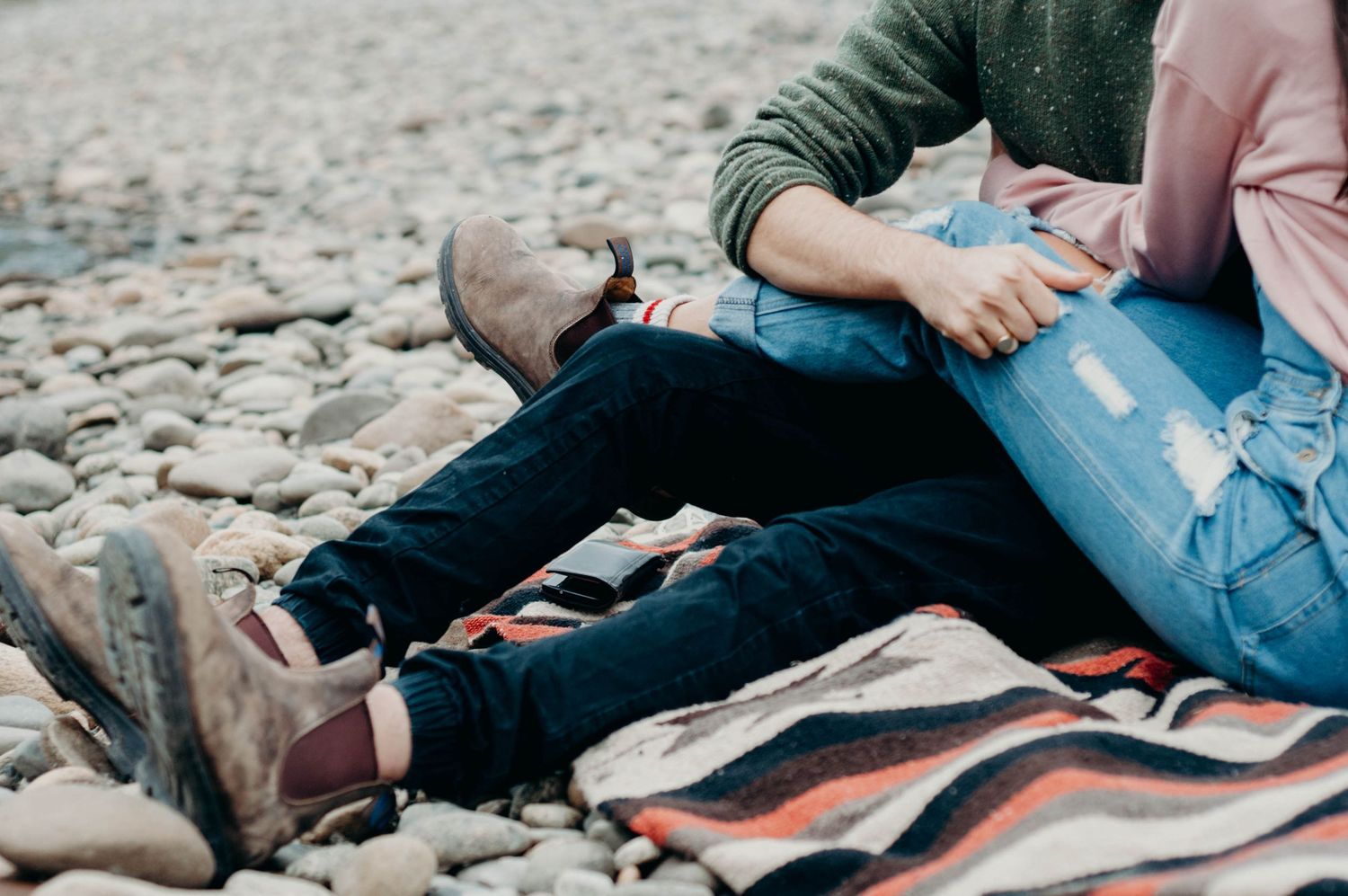 Cuddled up bodies of newly engaged couple on a blanket.