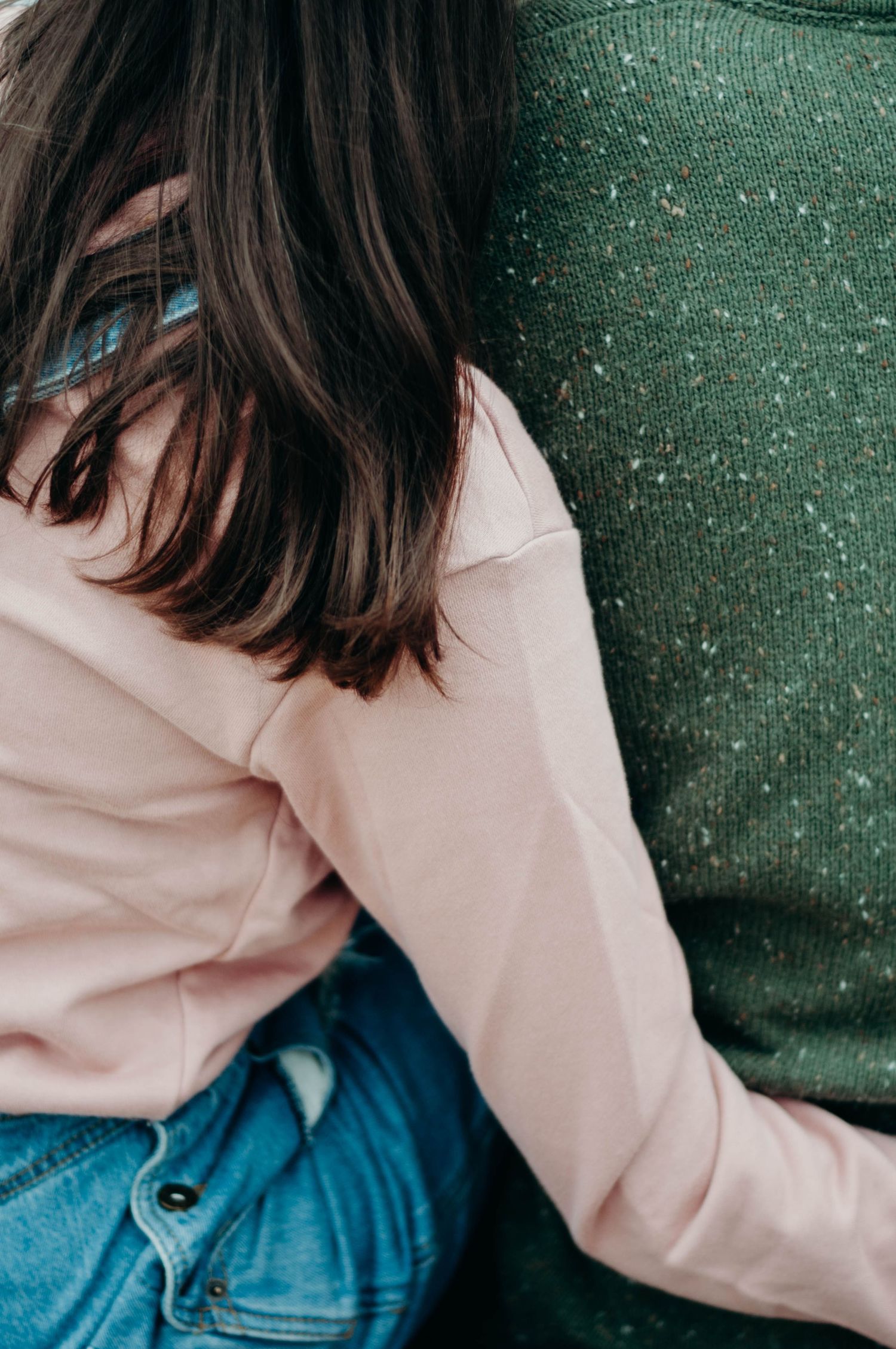 Fiancee wraps her arm around her partner.