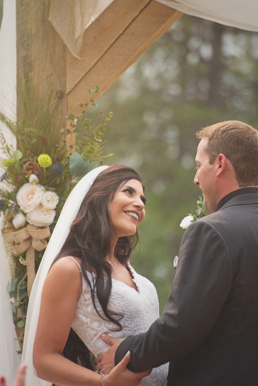 The bride looks at her new husband lovingly under the altar during their wedding ceremony.