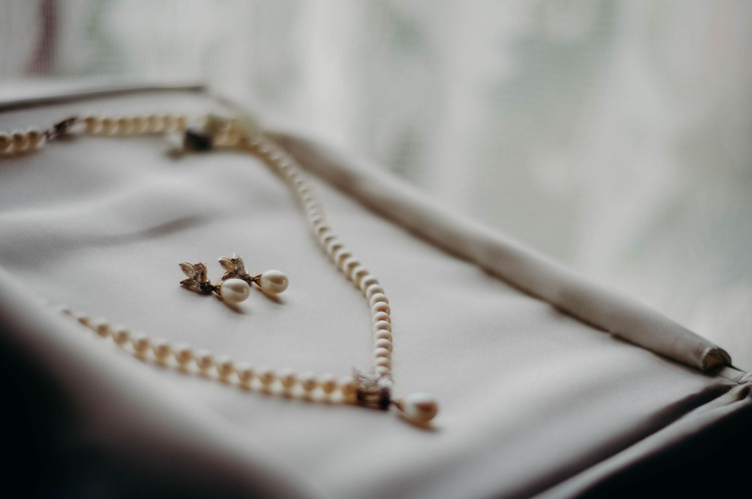 Close-up of the bride's pearl earrings and necklace.