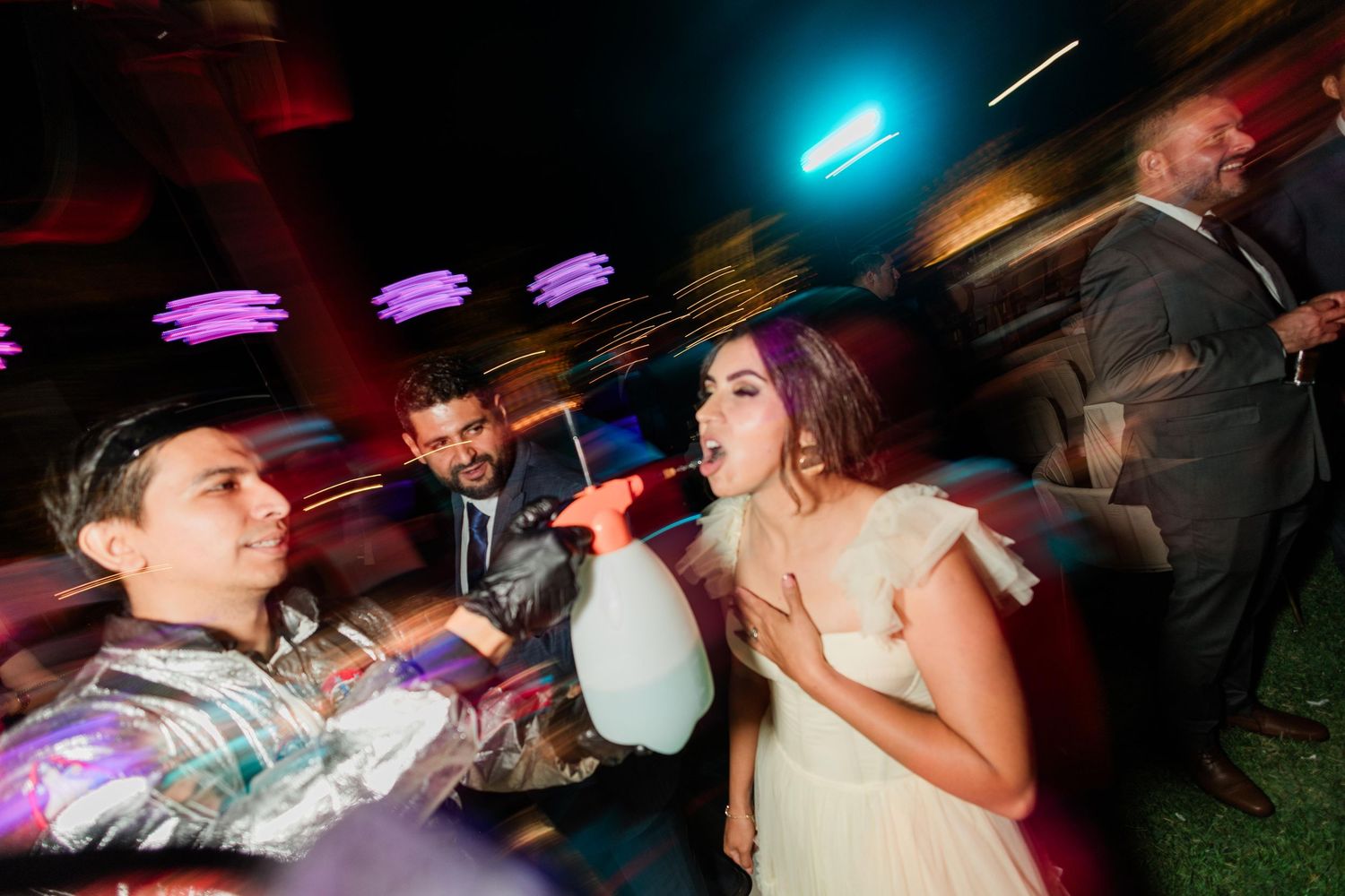 Group singing and celebrating at lively wedding reception.