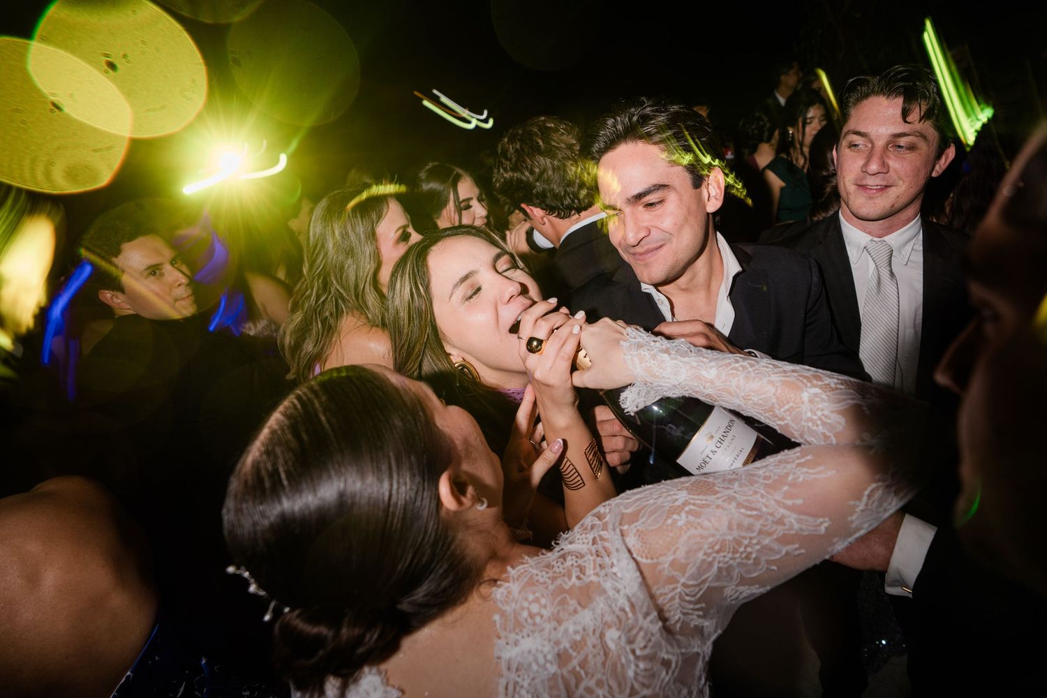 Bride and groom sharing a joyful moment on the dance floor surrounded by guests.