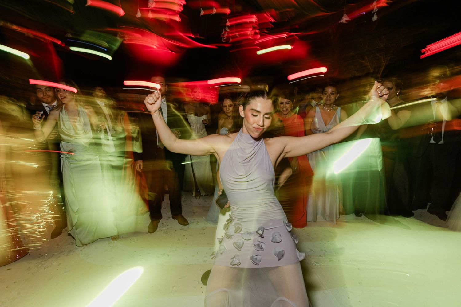Woman dancing energetically at party with motion blur effect.