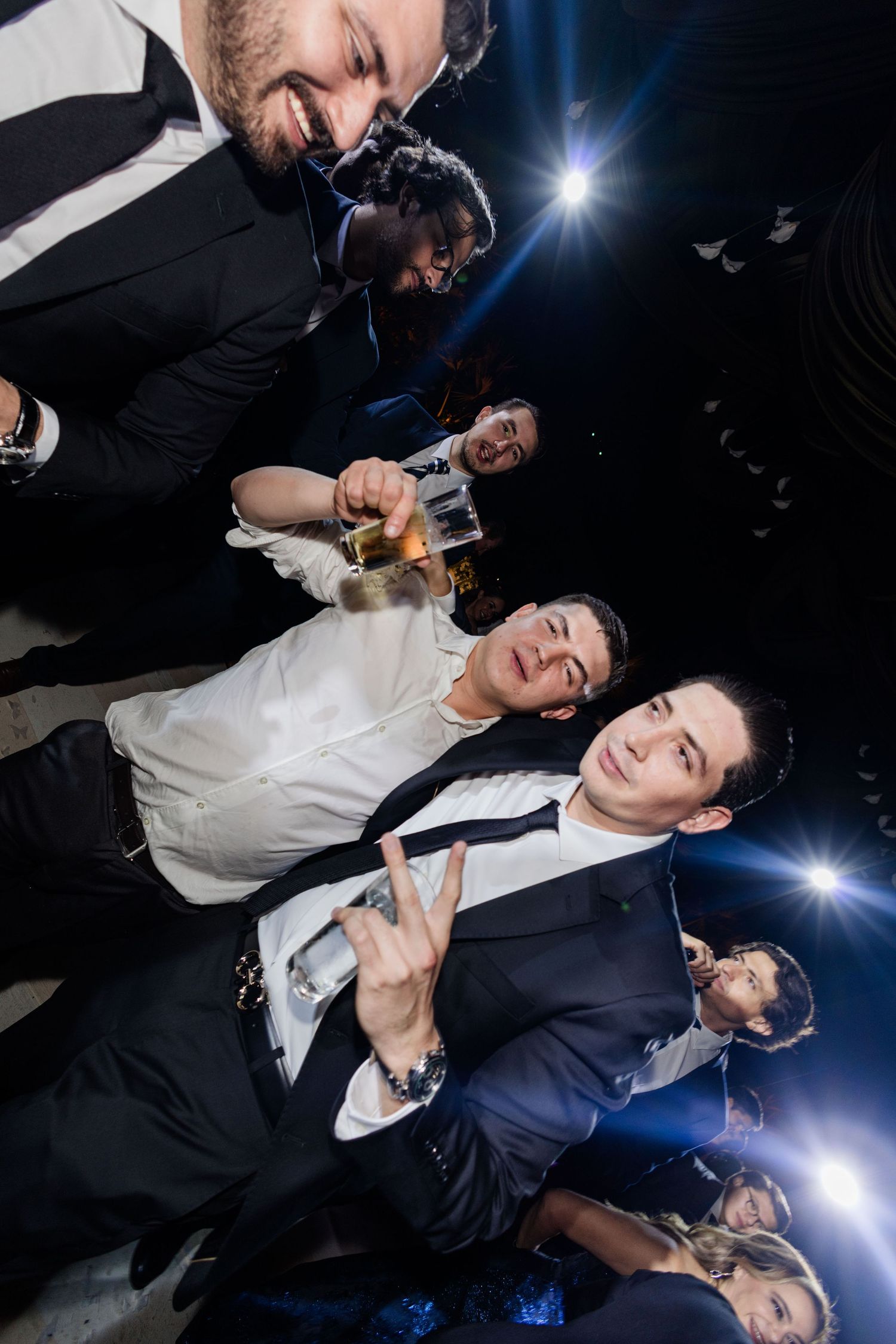 Group of men posing for fun upside-down photo at wedding.