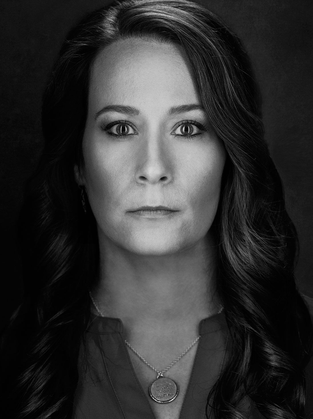 Black and white portrait of a serious woman with long dark hair.