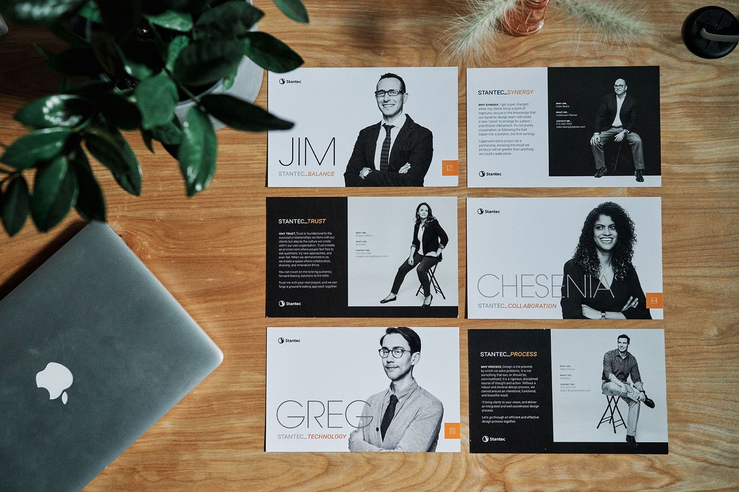 Stantec employee profile cards featuring Jim, Greg, and Chesni laid on a wooden desk.