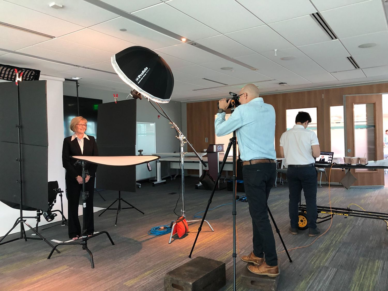 Professional photographer shooting executive portraits with studio lighting indoors.