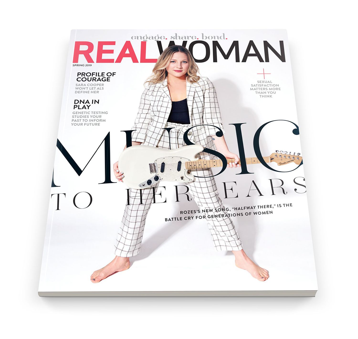 Real Woman magazine cover featuring a woman in a white plaid suit holding a guitar with headline Music To Her Ears.