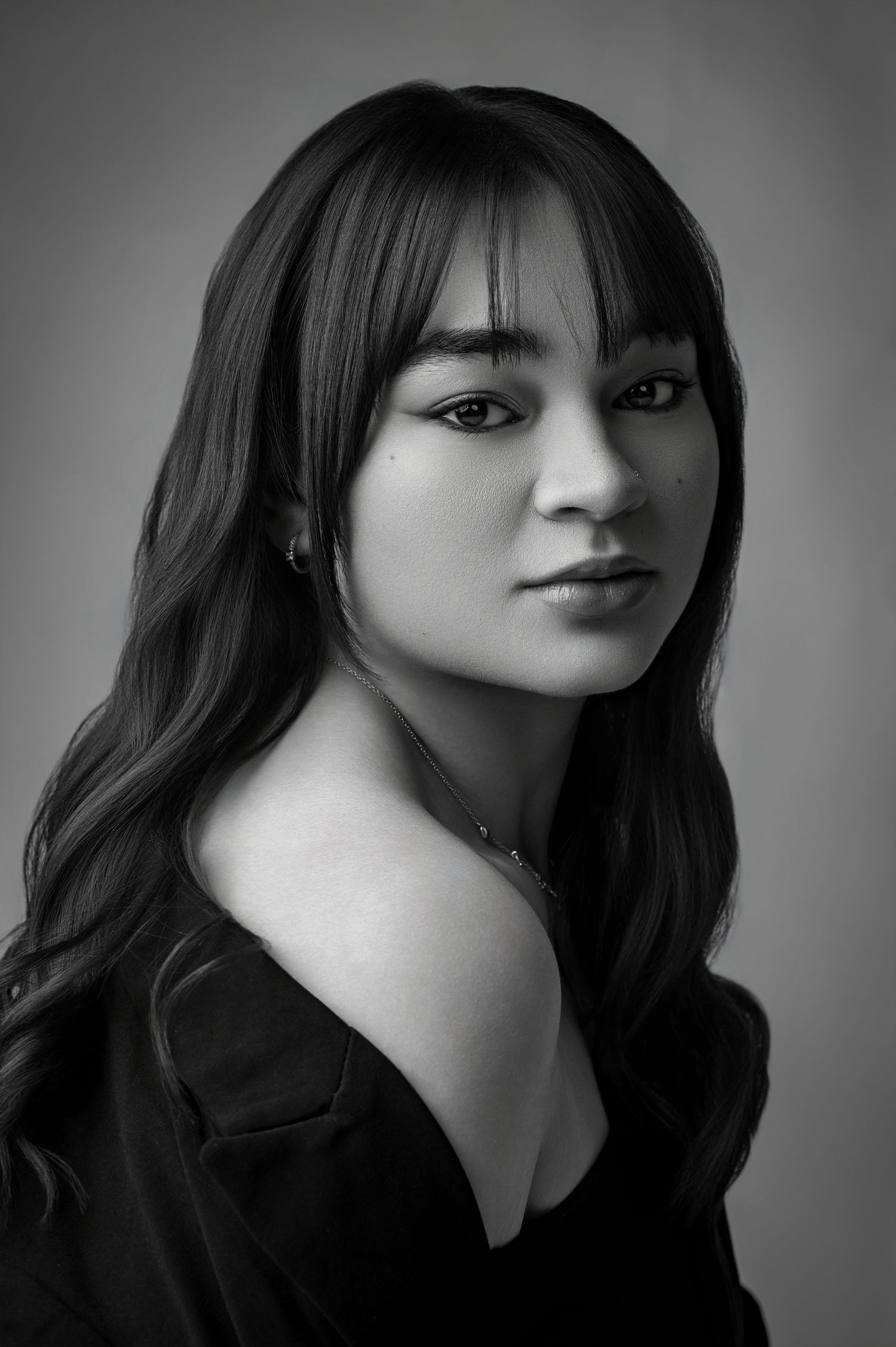 A black and white portrait series showing different angles of a woman with dark bangs and hair against a simple background.