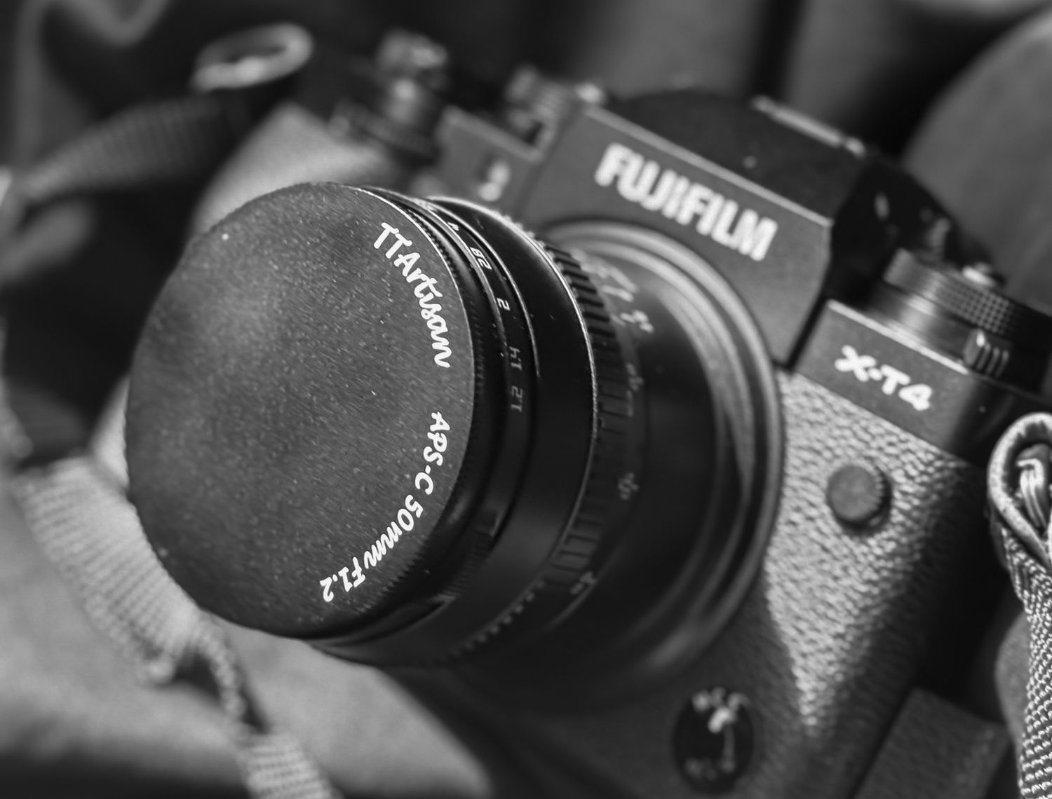 Close-up black and white photo of a Fujifilm X-T4 mirrorless camera with TTArtisan 50mm f1.2 lens.