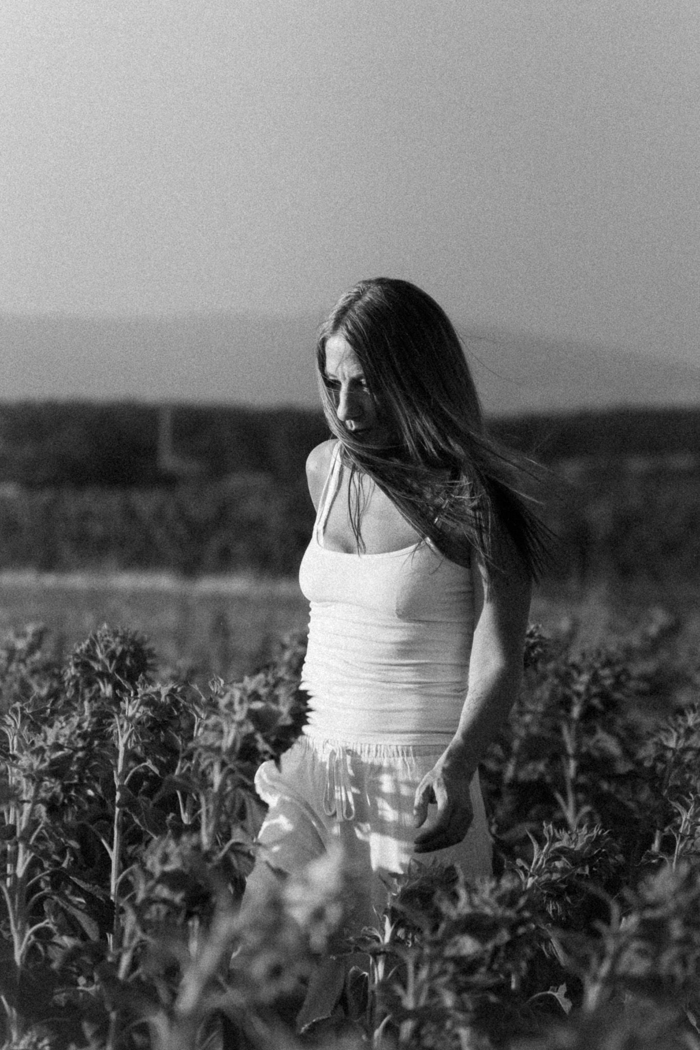 Portrait lifestyle en noir et blanc d'une femme en robe blanche dans la nature