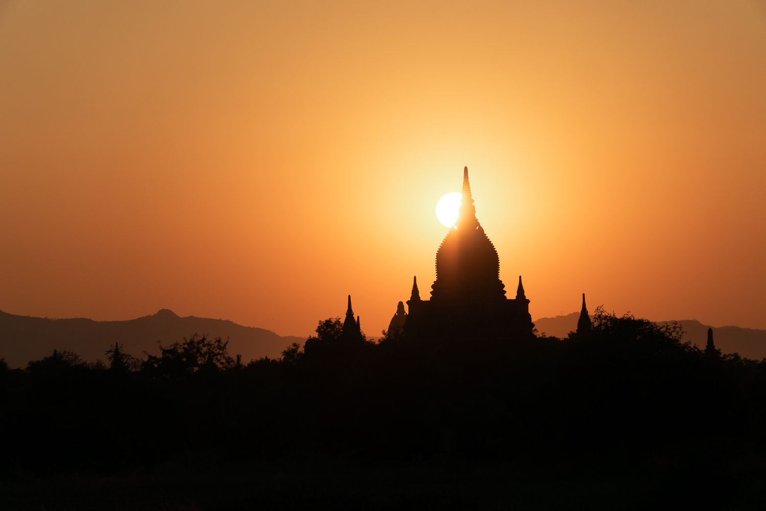 Coucher de soleil en contre-jour derrière la silhouette d'un temple asiatique