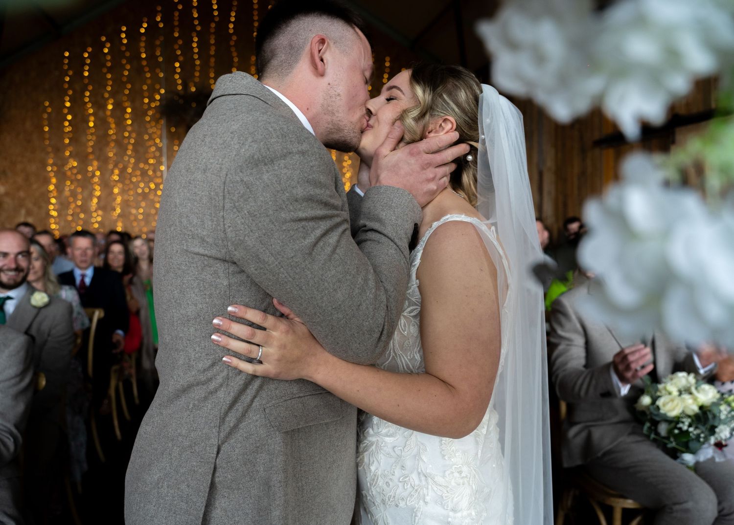 Bride and groom sharing their first kiss at the altar during wedding ceremony.