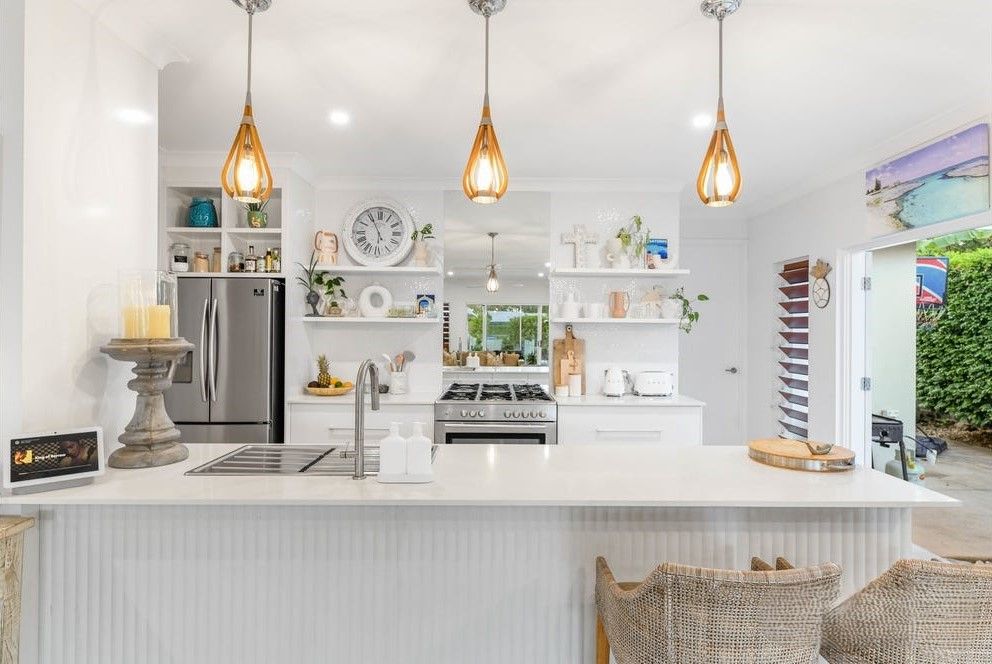A white open kitchen sparkling clean in Canberra. Stone benchtop safely cleaned. Nontoxic products safe for stone tops. Galley style kitchen