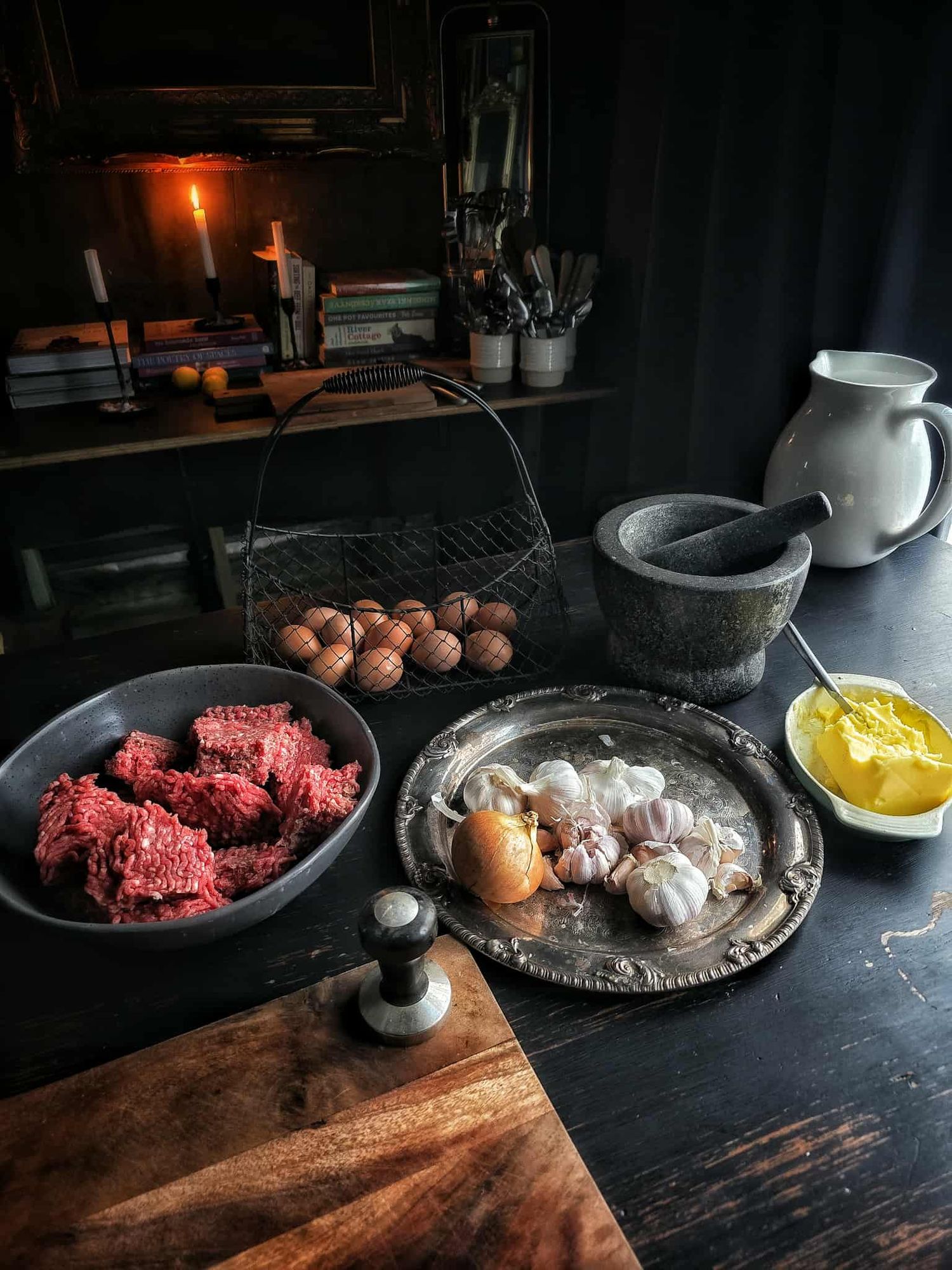 View from above of a black rustic kitchen table with ingredients displayed ready for cooking bolognese sauce.