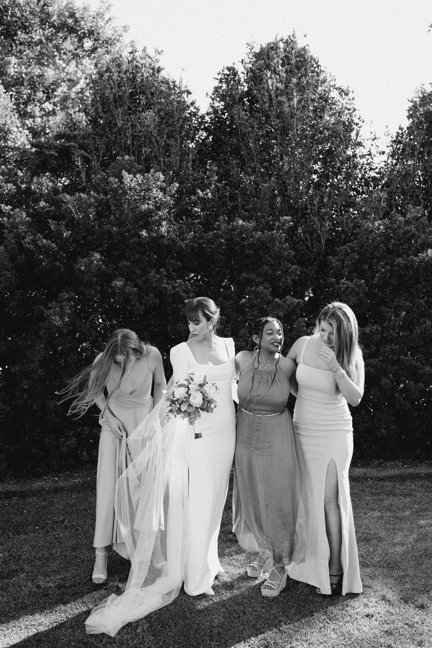 Bride standing with bridesmaids in a relaxed, documentary moment
