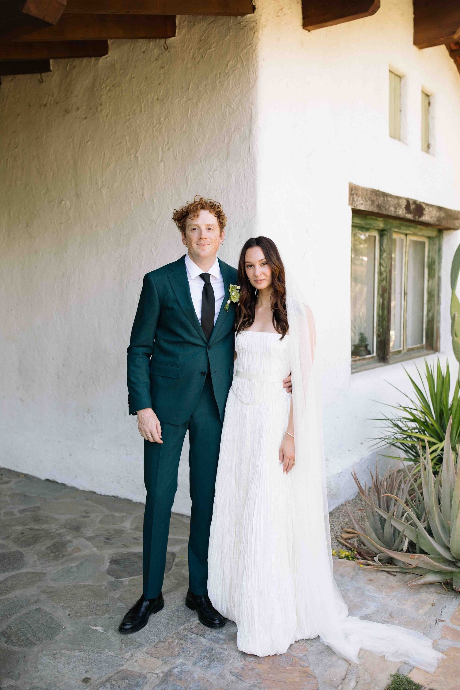 Natural wedding portrait of a bride and groom standing together outside