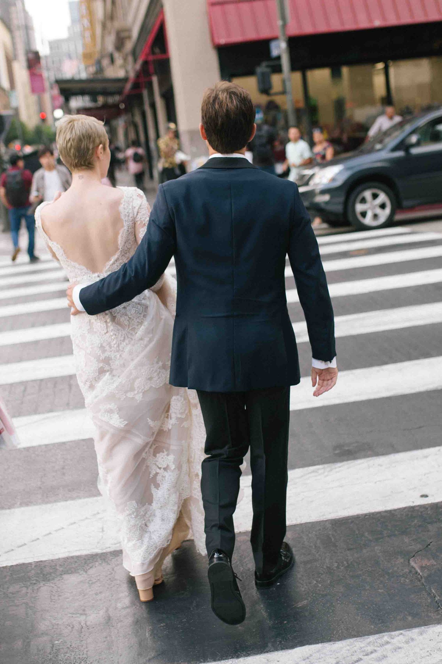 Bride and groom crossing the street together in a candid city moment