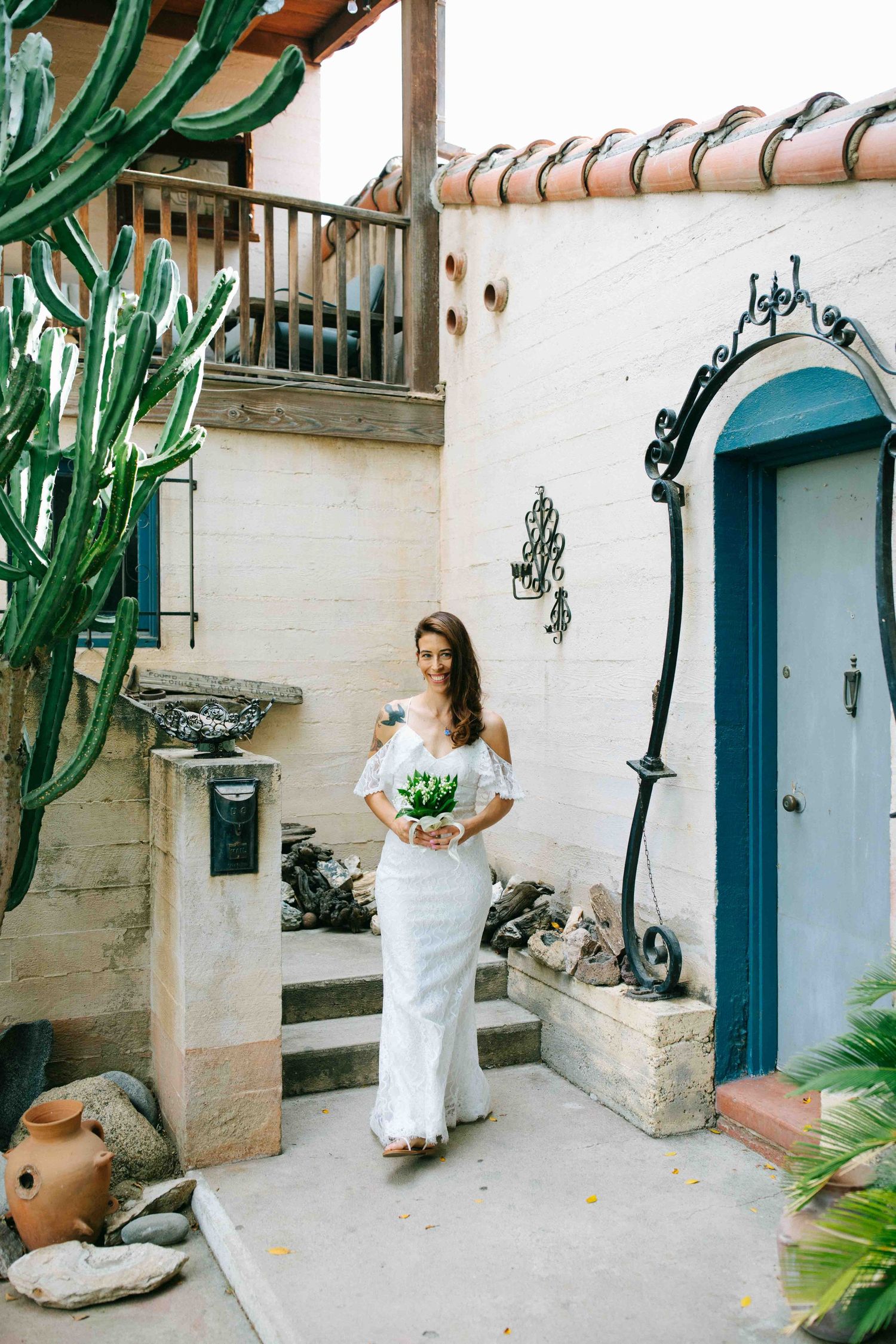 Bride walking through a sunlit courtyard on her wedding day, captured in a documentary style