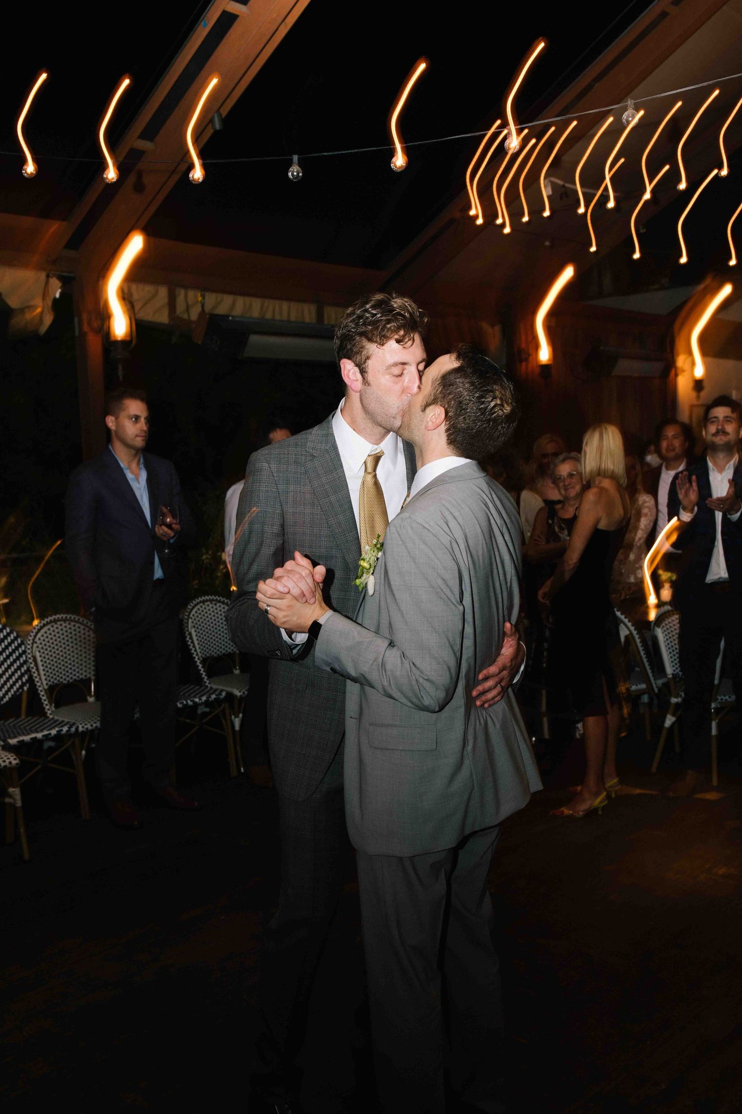Documentary wedding reception moment with guests dancing at night