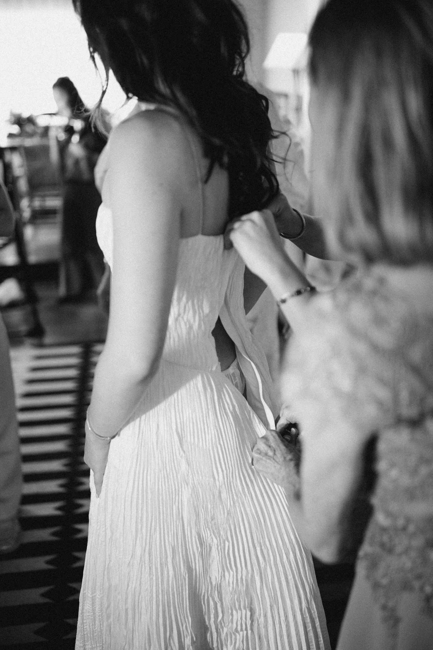 Documentary moment of a bride getting ready with help from her mom