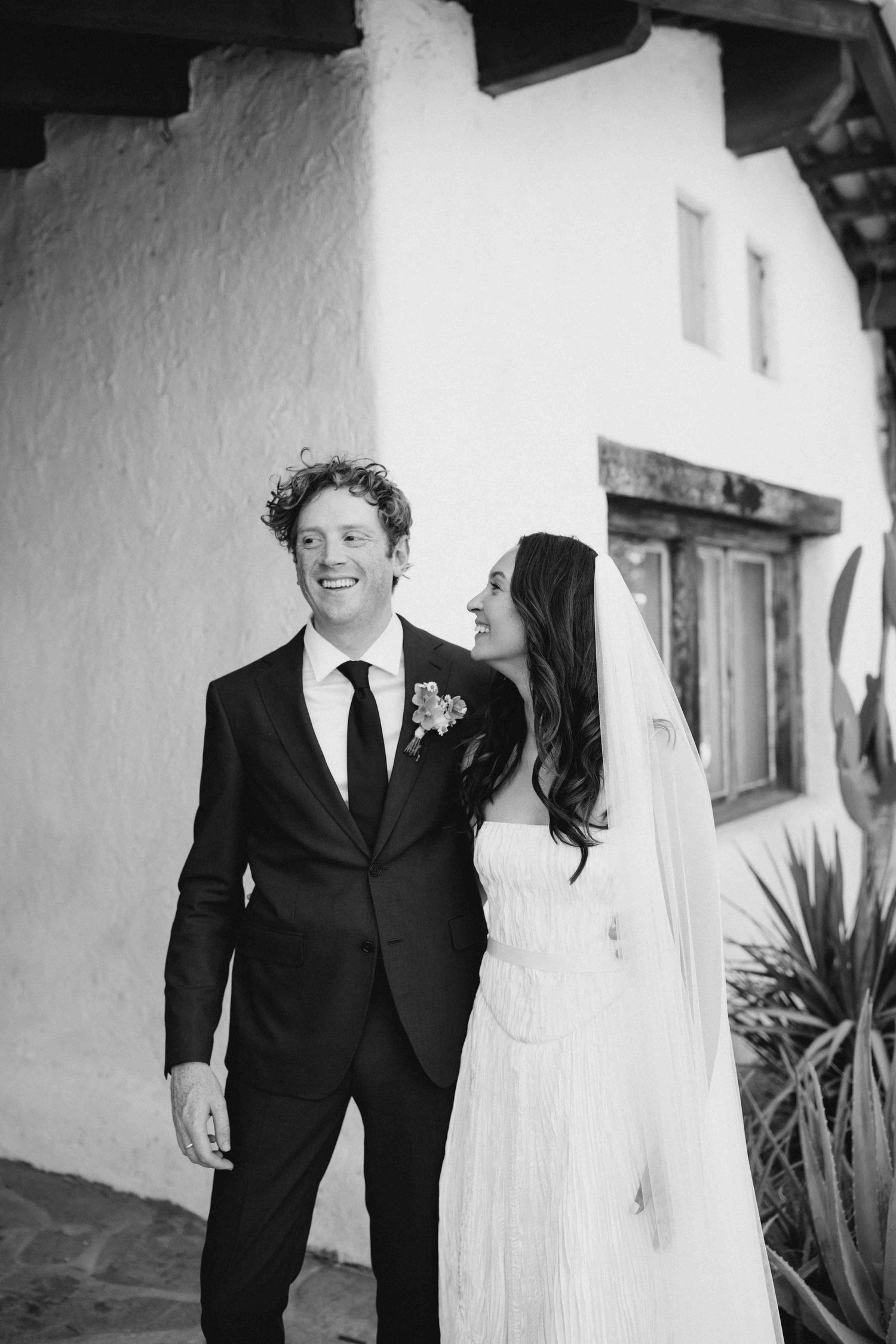 Candid documentary wedding portrait of a bride and groom walking together and smiling