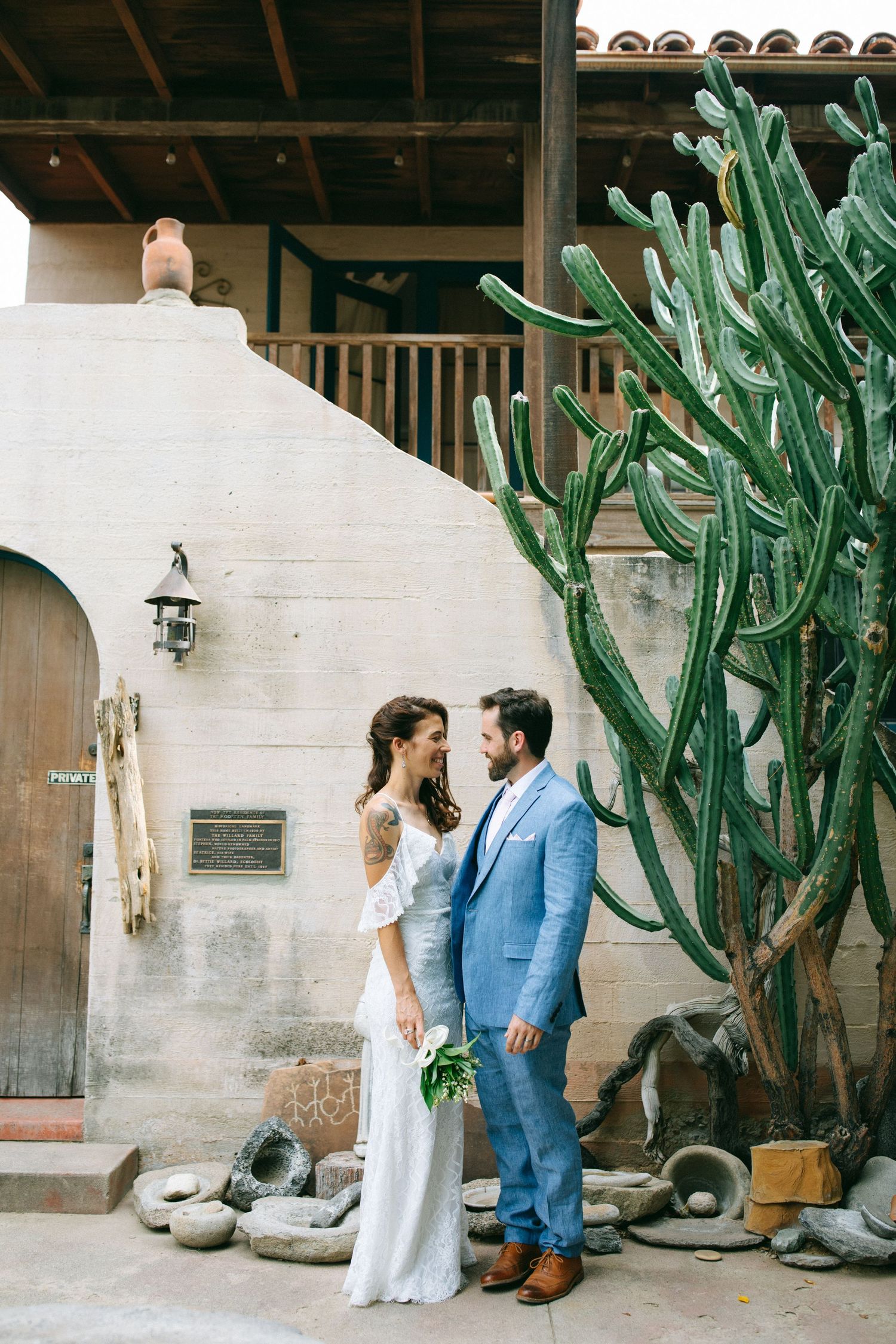 Bride and groom standing together near a desert-style wedding venue