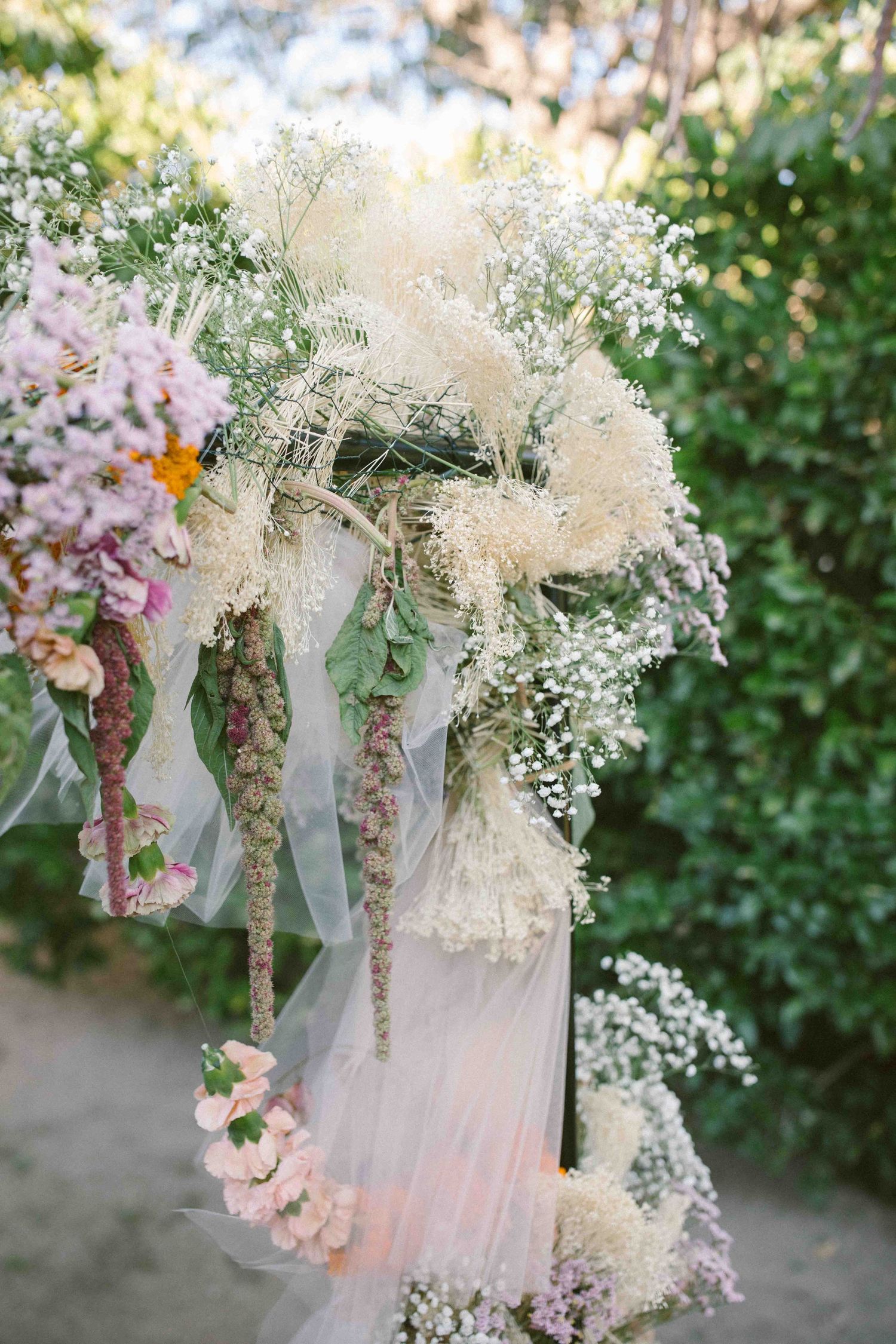 Close-up of wedding ceremony arch with natural flowers