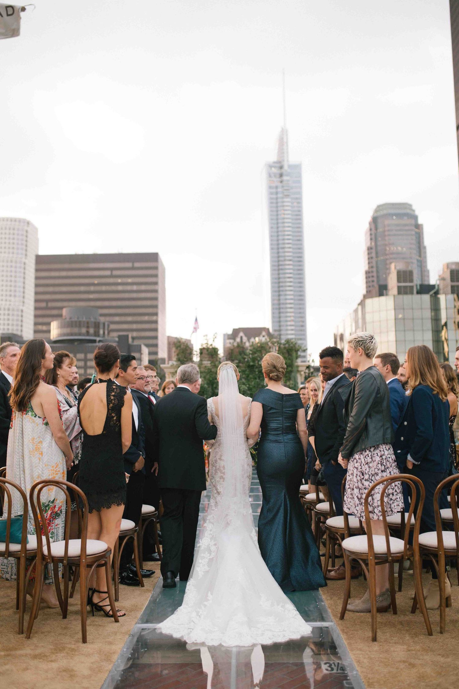 Outdoor wedding ceremony with guests and city skyline in the background