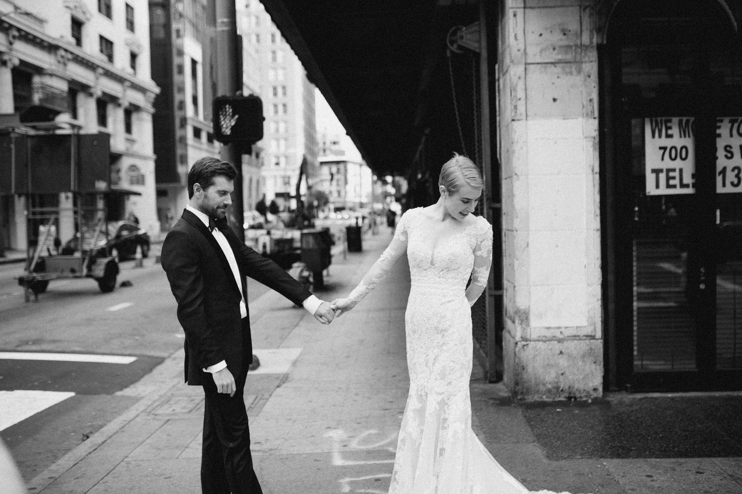 Bride and groom standing together on a city street in an unscripted moment