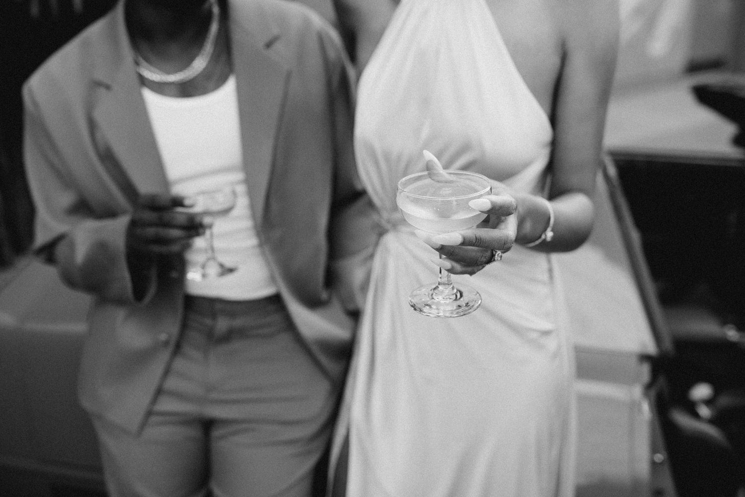 Unscripted moment of bride and groom holding drinks during a reception