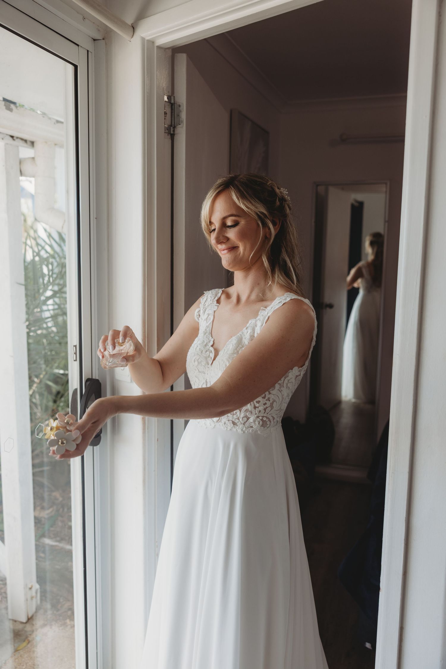 A flowing white wedding dress with lace details captured in a bright indoor setting.