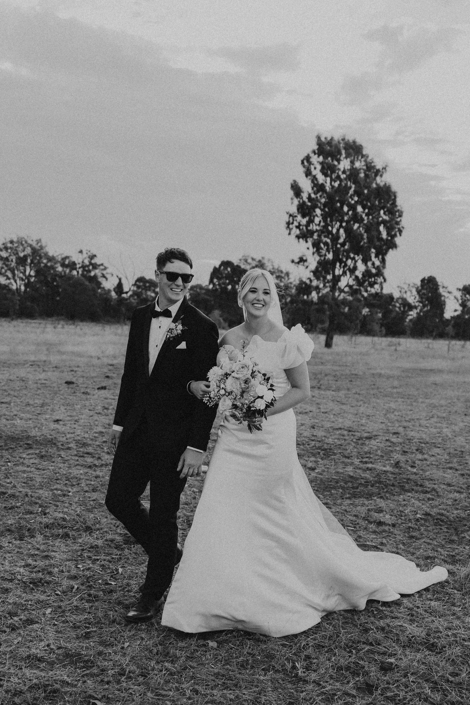 Black and white wedding photography sequence capturing playful moments in outdoor field setting.