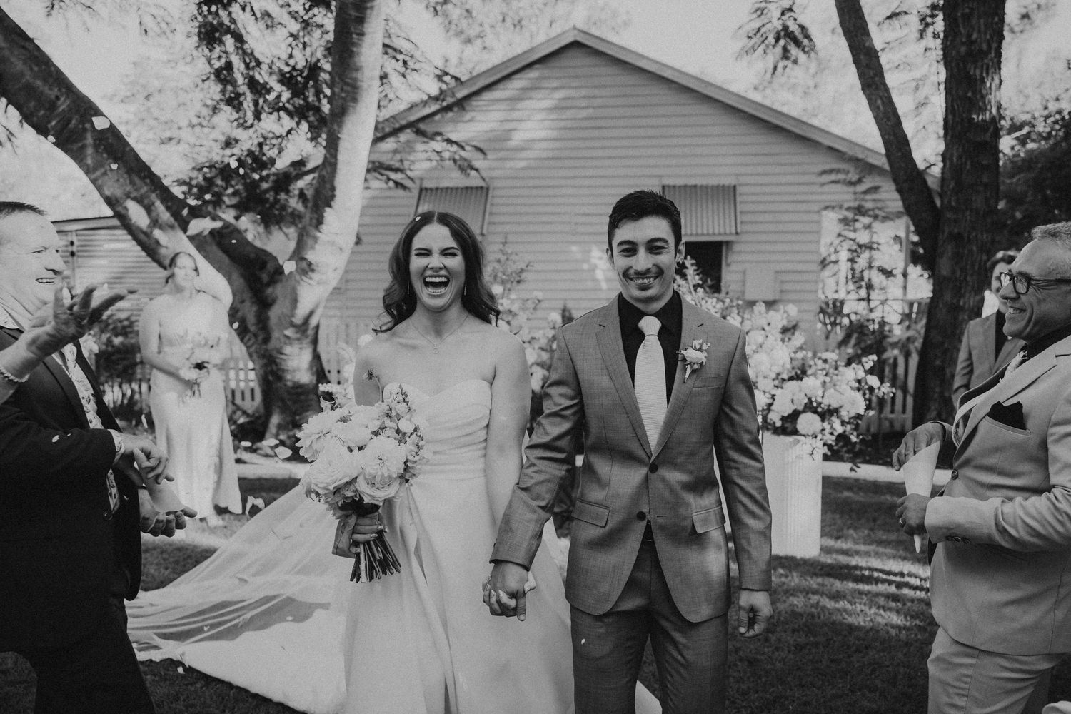 Black and white photo of newlyweds walking hand in hand at outdoor ceremony Rockhampton Wedding