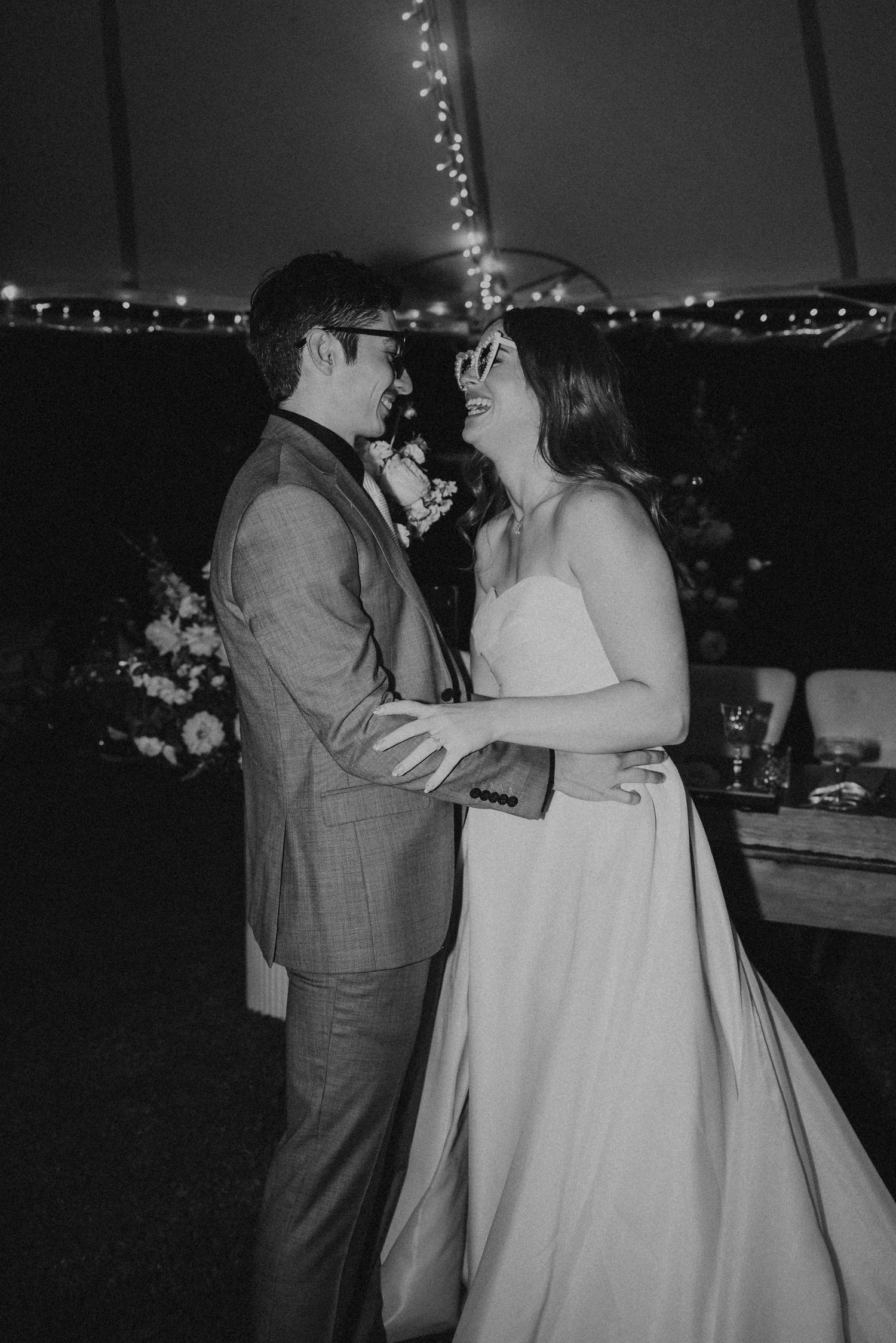 A couple shares a romantic dance outdoors at night with string lights twinkling in the background. St aubins wedding
